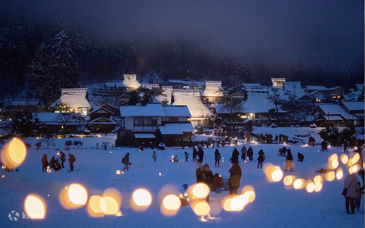 "A winter night view of Kyoto illuminated with glowing lanterns and light-up displays across historic streets and temples."