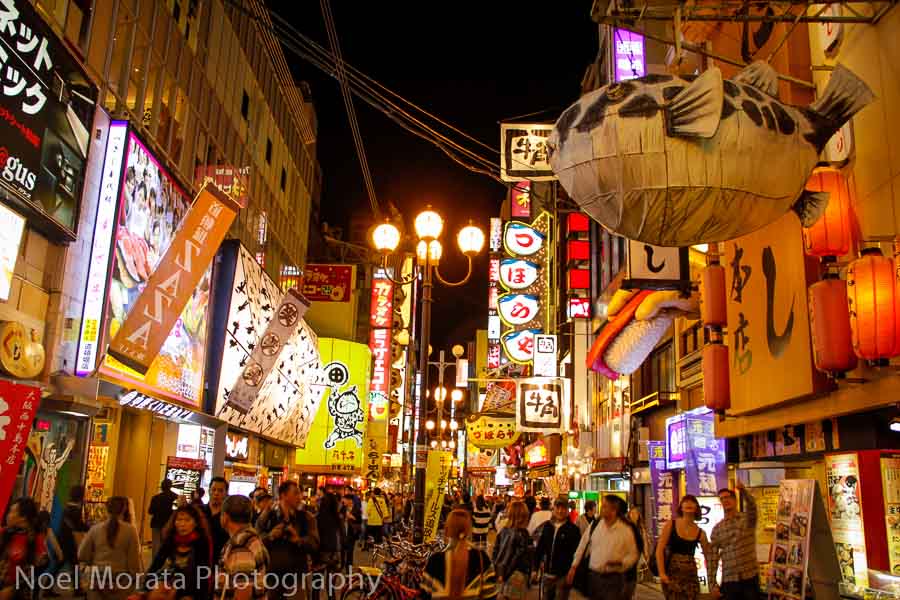 Winter night view of Osaka’s food streets with warm lantern lights, street vendors, and steaming dishes creating a cozy seasonal atmosphere.